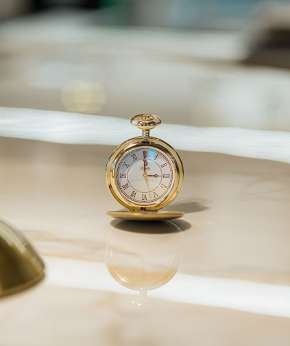 Gold pocket watch on a refined marble surface